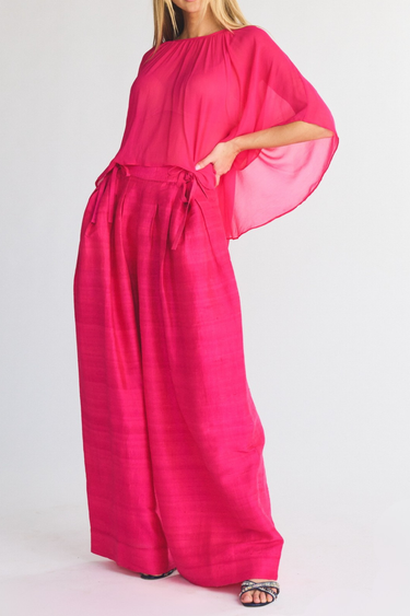 Pink top and wide leg silk pants with tie details on a white background