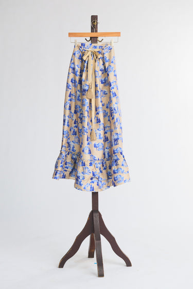 Skirt with blue floral pattern on a wooden hanger against a white background