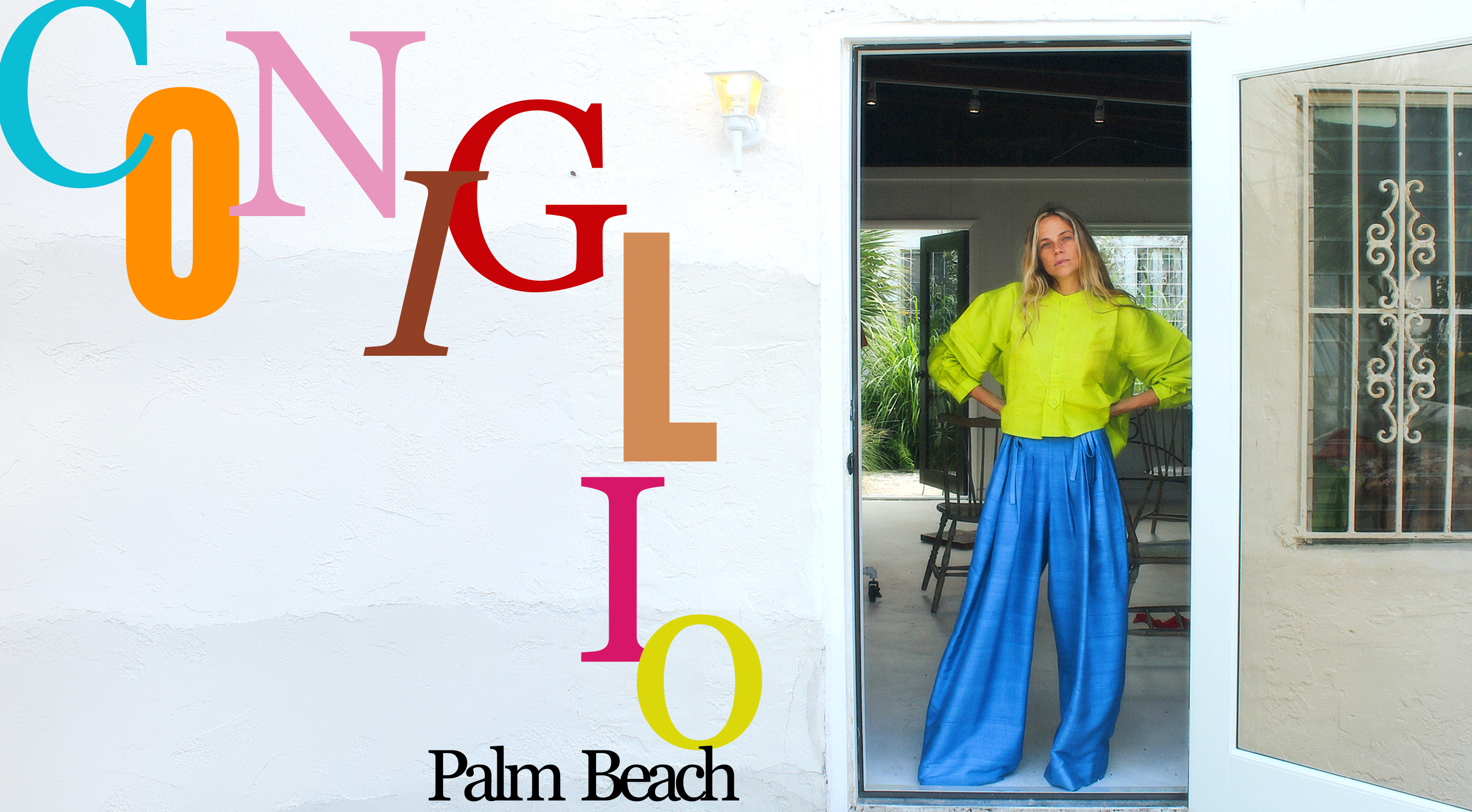 A woman stands in a doorway wearing a bright lime green long-sleeve top and shiny royal blue wide-leg pants. The left side of the image features a large stylized colorful 'CONGLIO' logo on a white stucco wall, with 'Palm Beach' written below.