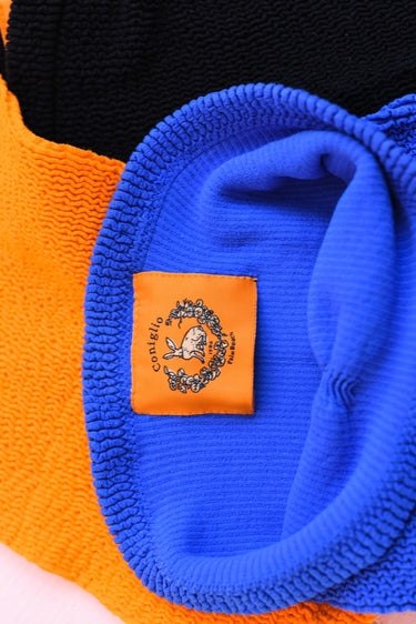 Close up of blue strapless top and Coniglio Palm Beach tag.