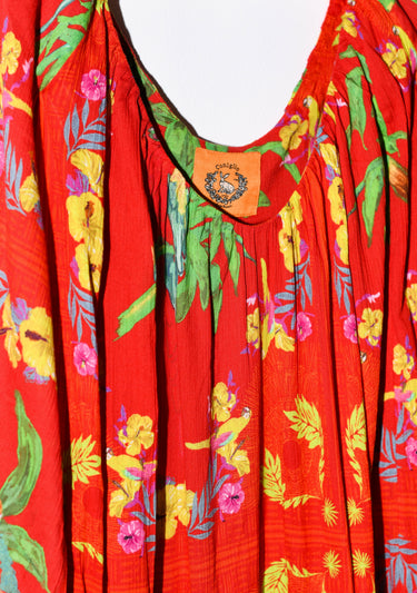 Red dress with colorful floral and leaf patterns on a plain background