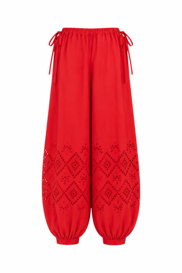 Bright red bubble-style pants with drawstring waist, elastic cuffs, and eyelet cutout eyelet details on the lower legs, shown against a plain white background.