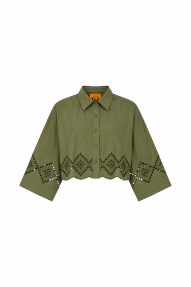 An olive green cropped button-up shirt with a pointed collar and a geometric diamond pattern of cutout eyelet details along the lower front and sleeves, displayed on a solid white background.