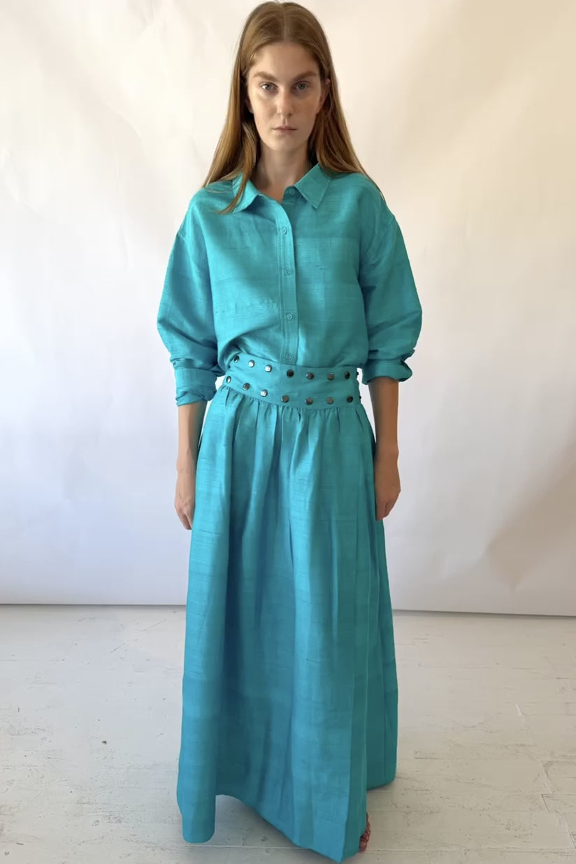 Video of girl in teal blue skirt snapping and unsnapping the skirt. 